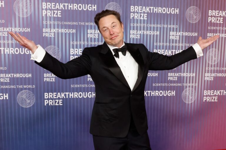 Elon Musk gesturing with open arms at a public event, symbolizing his expanding influence in U.S. government reform initiatives like DOGE.