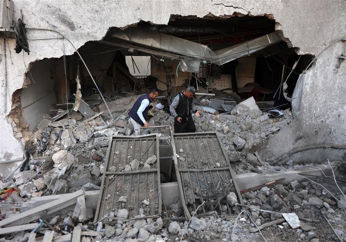 Two men inspect the rubble of Al-Ahli Baptist Hospital after an Israeli airstrike in Gaza City, April 2025.