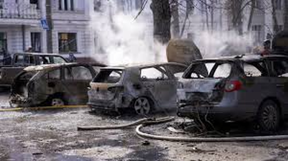 Burned and smoking cars line a street in Ukraine following a missile strike.