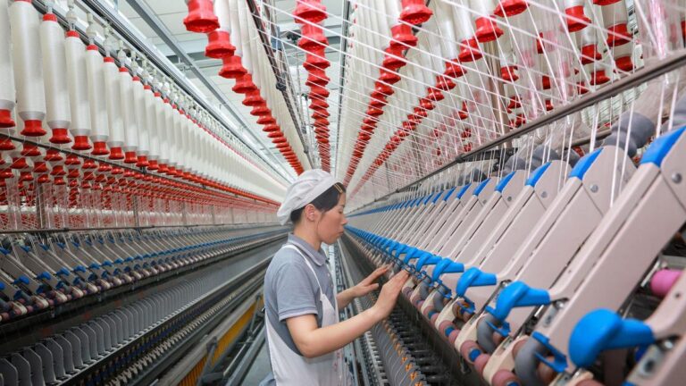 A factory worker in China operates machinery at a high-tech textile production line, reflecting the country’s industrial resilience in early 2025.