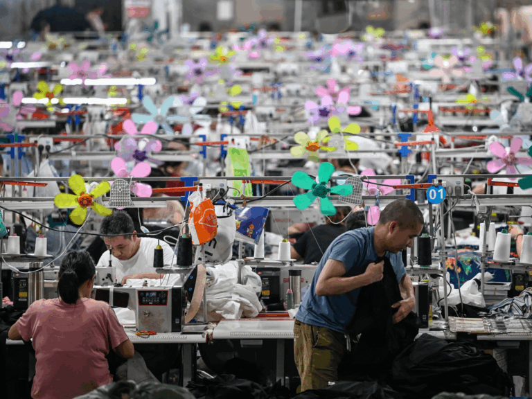 Garment workers sewing in a brightly decorated Shein facility, illustrating the Vietnam warehouse tariff strategy to reduce U.S. trade exposure.