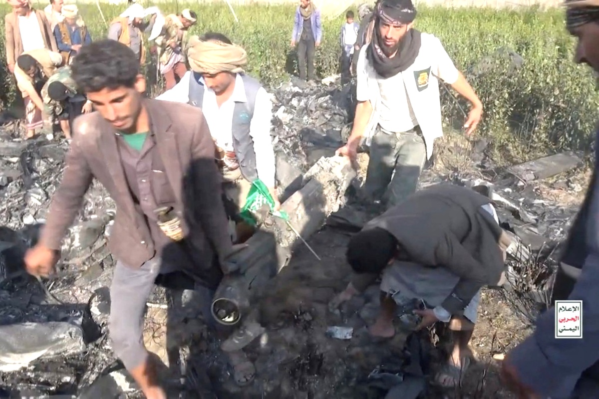 Houthi fighters inspect the wreckage of a downed U.S. drone, highlighting the rising trend of US drone losses in Yemen.
