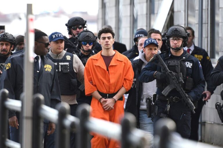 Luigi Mangione in an orange jumpsuit is escorted by heavily armed officers, drawing public focus in the latest Luigi Mangione case update.