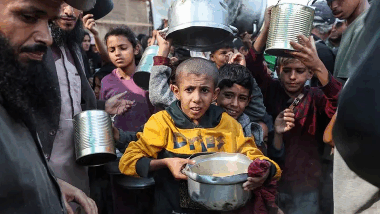 Children wait for food in Gaza amid growing shortages linked to Israel’s Gaza occupation plan and restricted aid access.