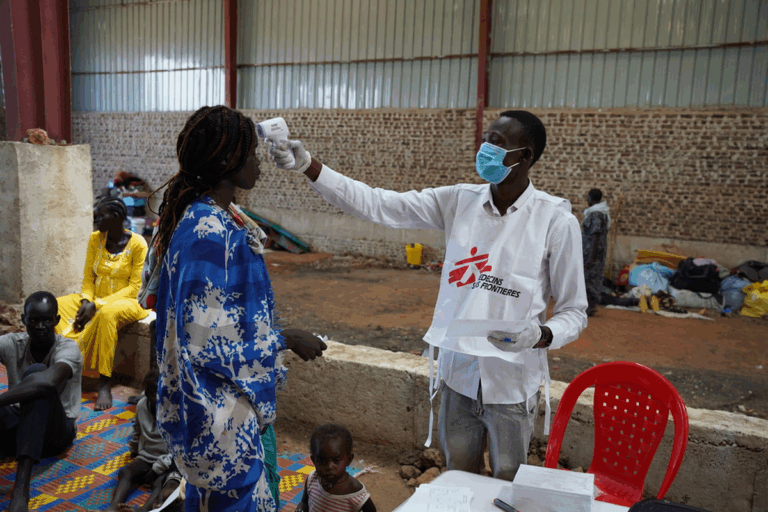 MSF worker checks temperature of a patient displaced by the South Sudan hospital bombing.